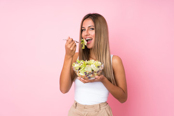 Young blonde woman with salad over isolated background