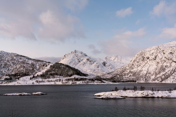 Norwegian fjords of northern Norway in winter. Snowy mountains and bright sky.