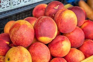 Sorted sweet peach fruits at the market. Selective focus