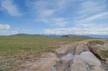 Mongolian Altai. Beautiful view of the mountain pass`s empty dirt road. Nature and travel. Mongolia, Bayan-Olgii Province