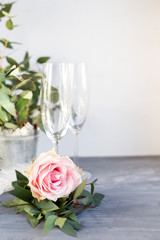 Composition with glass for champagne. Flowers and hearts on grey concrete background.