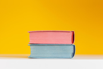 blue and pink books on yellow background