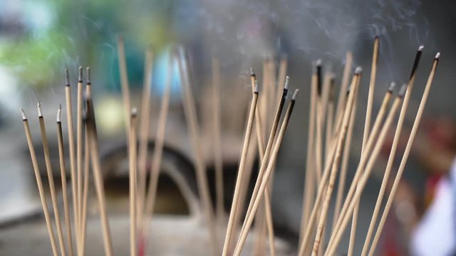Incense sticks on joss stick pot laced are burning and smoke use for pay respect to the Buddha..