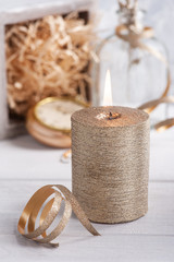 Fototapeta na wymiar Golden lit candle and ribbon
