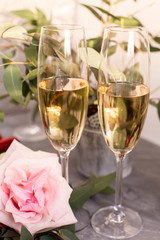Composition with glasses of vine and flowers on grey concrete background.