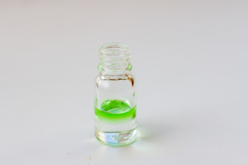 green aroma oil for aromatherapy in a glass bottle on white background