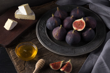 Fresh ripe figs. Breakfast with figs, cheese, honey and nuts. A few figs on an old wooden...
