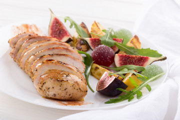 Baked chicken with fig and arugula salad. Chicken breast, fig, arugula. Dinner. Fried chicken breast with vegetables and figs. Dish with figs. fried chicken with figs and onions. Free space for text. 