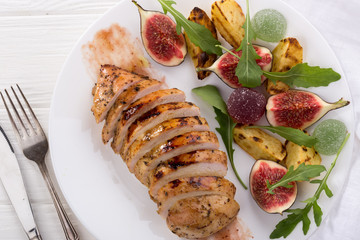 Baked chicken with fig and arugula salad. Chicken breast, fig, arugula. Dinner. Fried chicken breast with vegetables and figs. Dish with figs. fried chicken with figs and onions. Free space for text. 