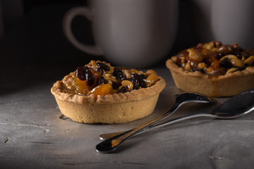 tart with salted caramel. Tart with nuts and caramel on a rustic background. Tartlets with dried...