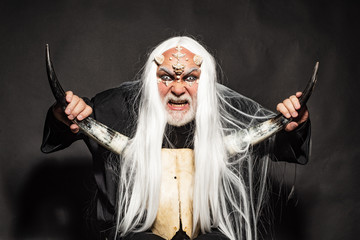 Druid on black background. Alien with dragon skin and grey beard. Ancient alchemy. Monster with...