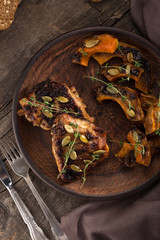 Chicken baked with pumpkin. Baked chicken with pumpkin. Roasted pumpkin and meat. Chicken pieces on a cushion of vegetables. Autumn dish. Everyday autumn kitchen. Orange colors. 