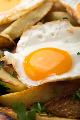Breakfast in the pan. Fried potatoes with eggs in a skillet. Food bachelor. Cooked by a man. Hot and fresh. Homemade breakfast on black table. Fried eggs and sweet potato hash in cast iron skillet Fre