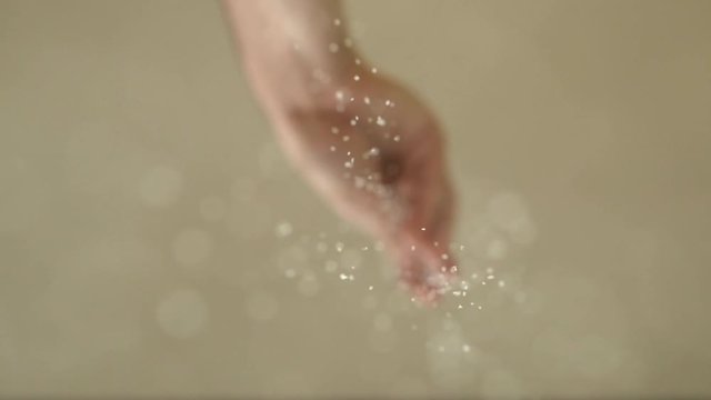 The male hand is heavily salting something. Cook with spices