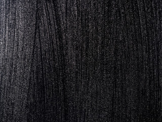 Black surface covered with small water drops