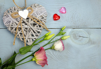 Horizontal composition to the day of St. Valentine with a wicker heart, glass hearts and lisianthus flowers.