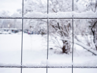 Detail of metal fence covered with snow