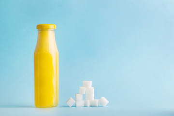 the problem of hidden sugar in juices, a glass jar for juice with sugar on a blue background