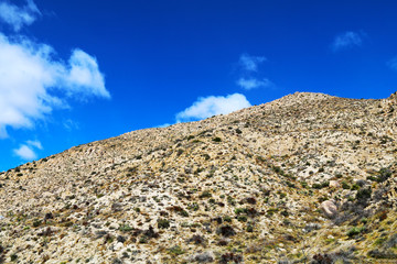 a rocky desert mountain against bright blue sky