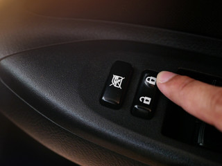 A man's hand pressing the button to lock the car.