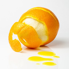 Orange halb geschält mit Safttropfen