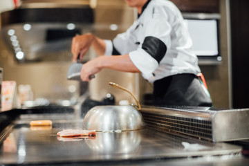 Hand of man take cooking of meat with vegetable grill, Chef cooking wagyu beef in Japanese teppanyaki restaurant