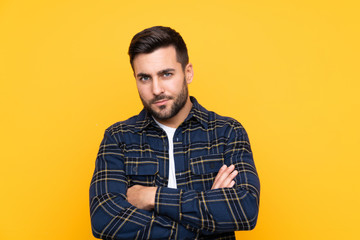 Obraz premium Young handsome man with beard over isolated yellow background feeling upset