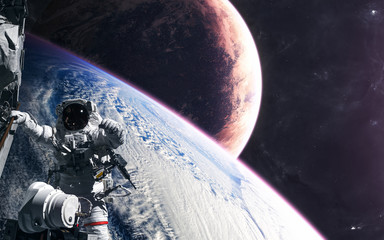Astronaut in orbit of a planet somewhere in deep space. Science fiction. Elements of this image...