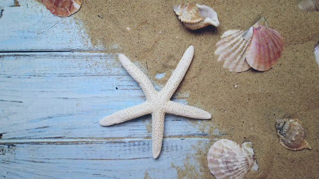 sea shells and starfish on a blue wooden background and sand. The concept of summer vacation