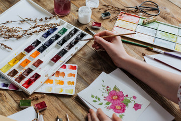 The young artist stretches the brush to the watercolor