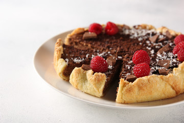 Chocolate cake with cottage cheese and raspberries on a light background. Background image, copy space