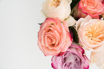 Feminine flatlay with pastel color roses on white background