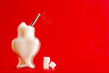 stop sugar, diabetes concept, glass jar in the shape of a heart with sugar, diabetes problem and heart disease in people