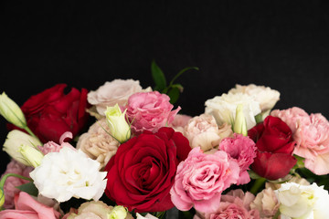 Red roses and blush carnations black background