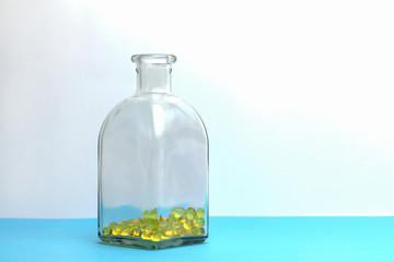 Capsules with fish oil, omega-3 and vitamin D in a glass bottle. Copy space - the concept of additional nutrition, good health, medicine, treatment of diseases, healthy lifestyles