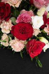 Red roses and blush carnations black background