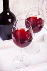 Fotobehang Two glasses with red grape wine with bottle on the background. Romantic dinner concept. © zulfiska