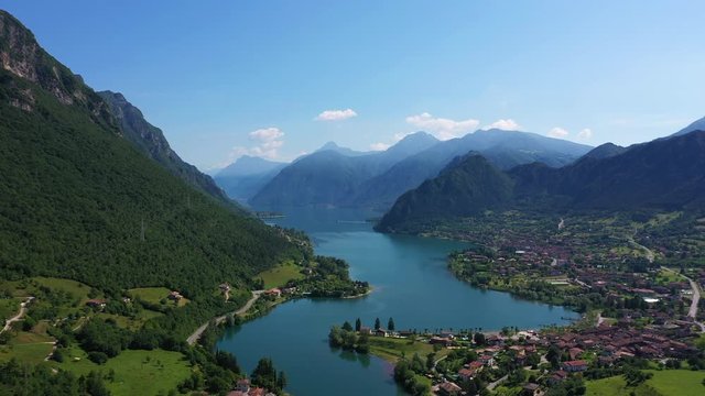 Panoramic view of the mountains and Lake Idro. Reflection in the water of the mountains, trees, blue sky. Aerial view