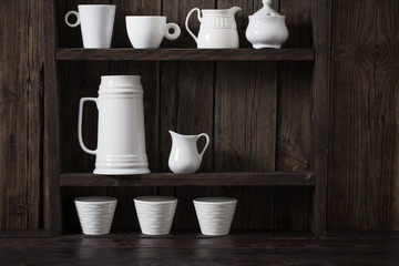white kitchen dishware on old dark wooden background