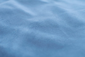 Close up light blue velvet textile background. Crumpled fabric.