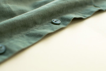 Close up green cotton textile background. Crumpled fabric of shirt.