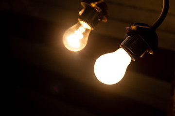 Energy-saving lamp and incandescent on a dark background
