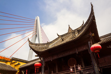 Chongqing, China - March 21, 2018: View of the pylon of a modern Dongshuimen bridge, sky and clouds from the courtyard of the imperial palace (museum) in the Chinese city of Chongqing.