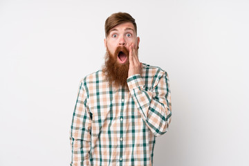 Redhead man with long beard over isolated white background with surprise and shocked facial expression
