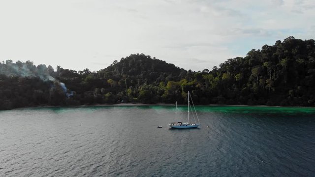 The Wonderful Scenery Of Green Lush Island In Thailand With a yacht and Glorious Trees and Cloudy Sky Above - Beautiful Tourist Destination - Aerial Shot