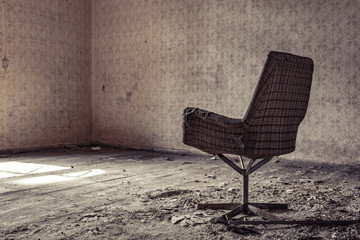 stary zniszczony fotel w opuszczonym budynku