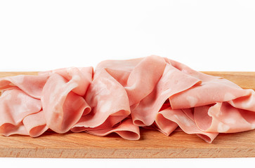 Front view of slices of mortadella chopping board on a white background