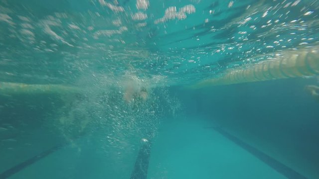 joven nadando bajo el agua en una picina / alberca