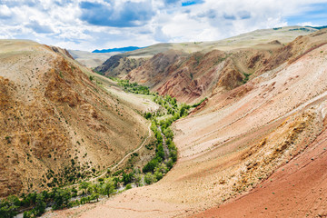 Kyzyl-Chin gorge and river in Altai Mountains, aerial drone view.  Hiking trail in deserted rocky canyon in sunny summer day. Wilderness scenery near Chagan-Uzun, Altai Republic, Russia