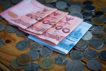 Thai bank note and Coins on wood table